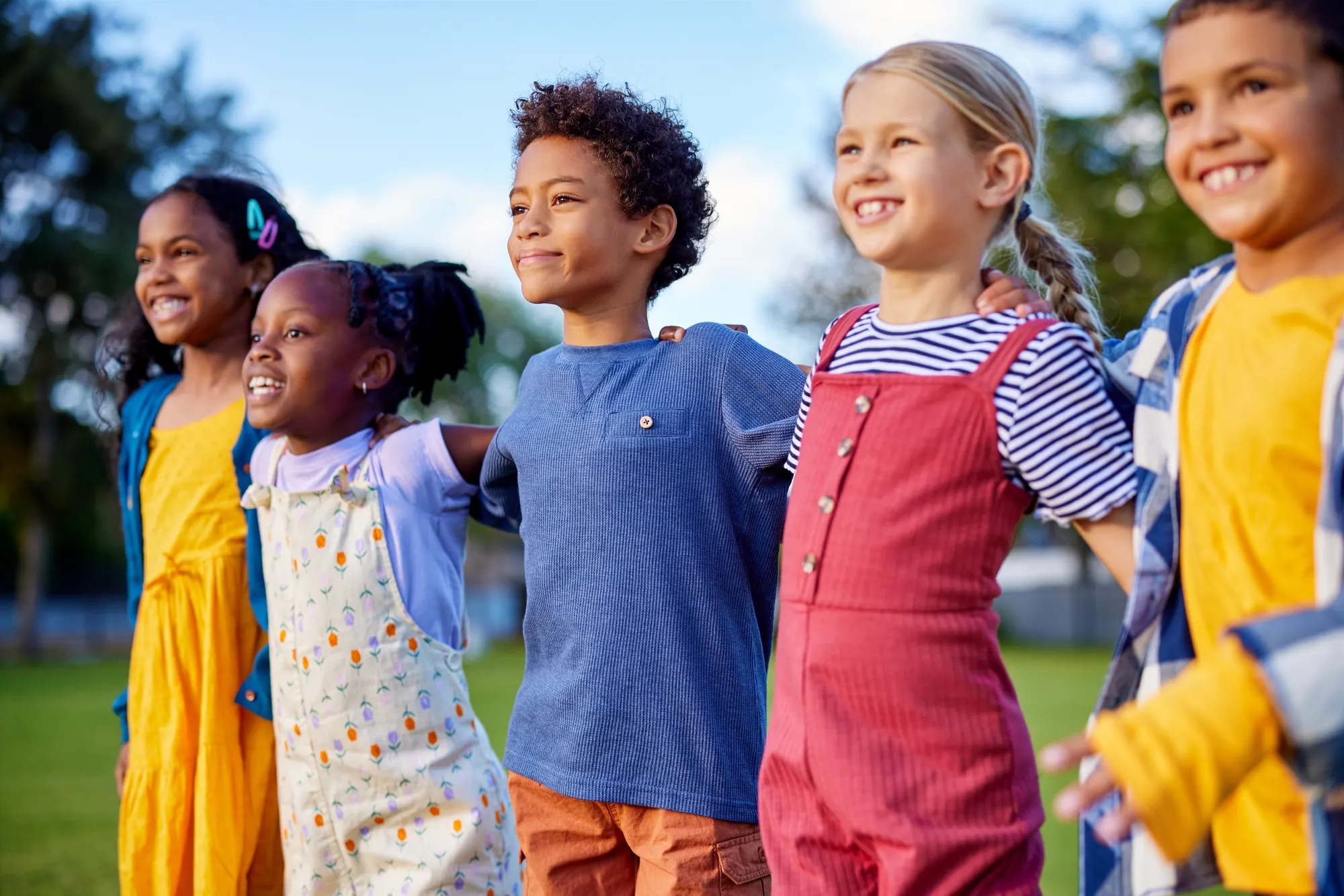 Line of smiling children standing together outdoors