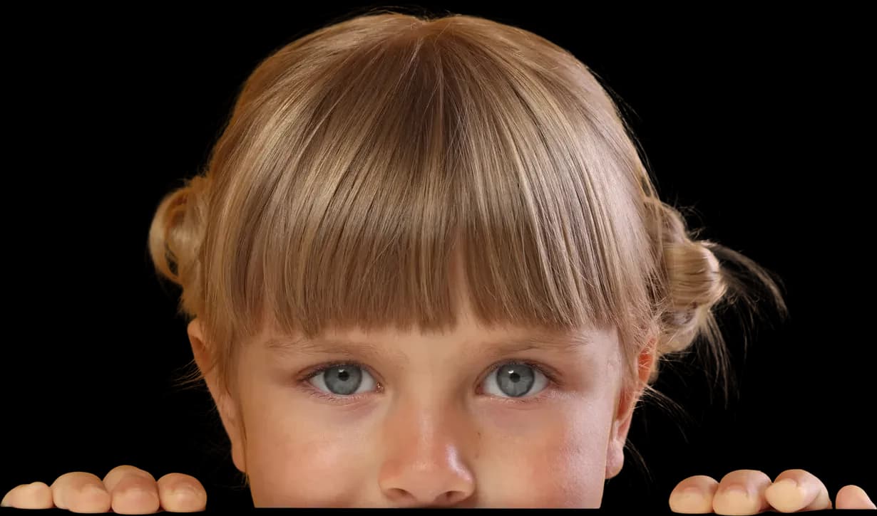 Young girl peeking over the edge with her fingers gripping the top